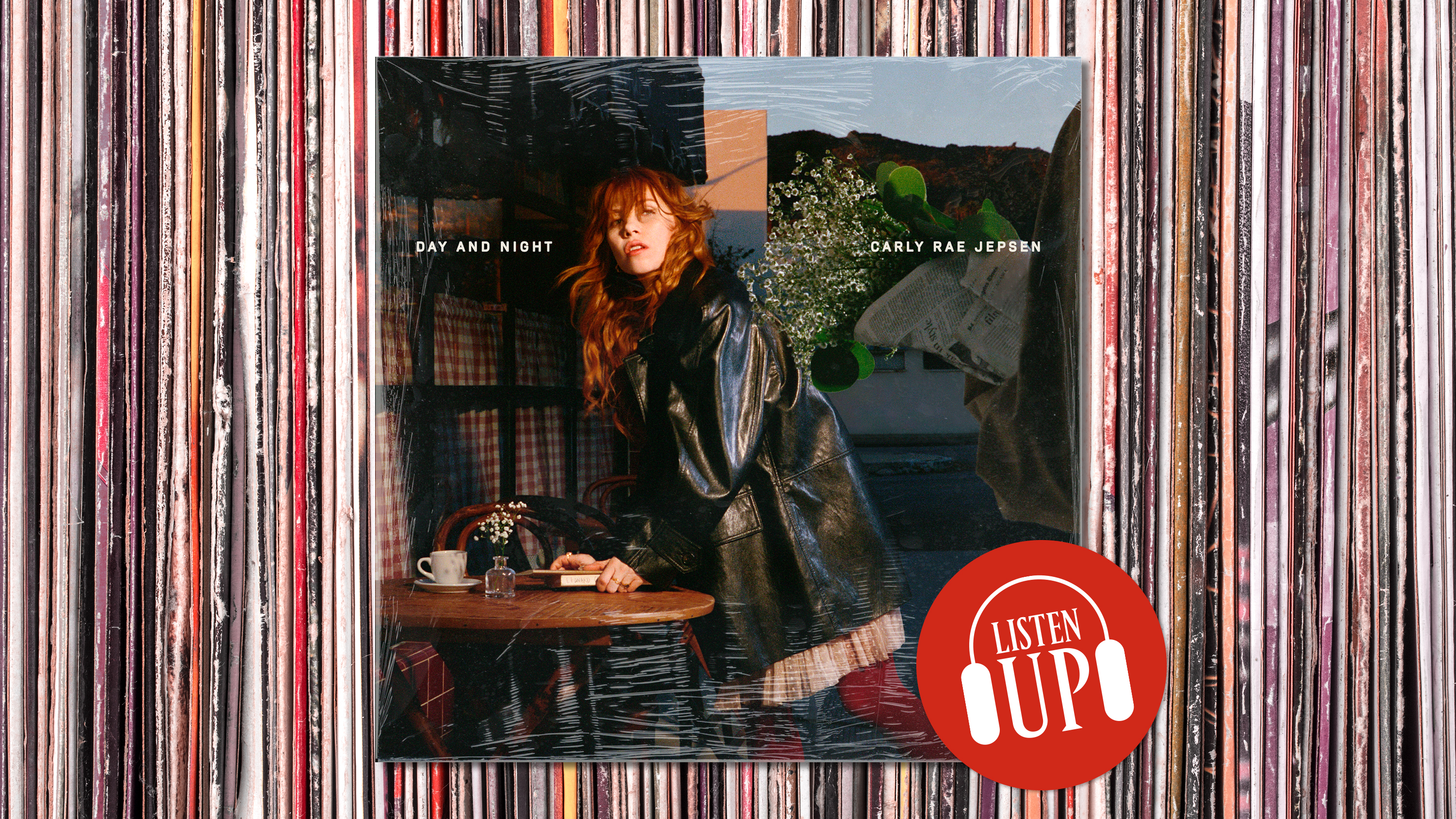 Carly Rae Jepsen poses in a long trench coat leaning over a table with a collage behind her on the cover of her album day and night opposite the artwork for marie claire's listen up franchise