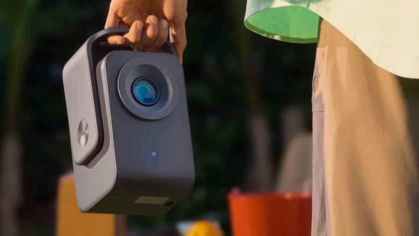 Lifestyle shot of someone carrying a TCL Projector C1