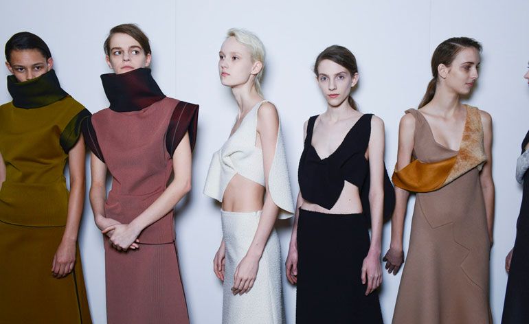 Five women in black, white, brown, and pink dresses 