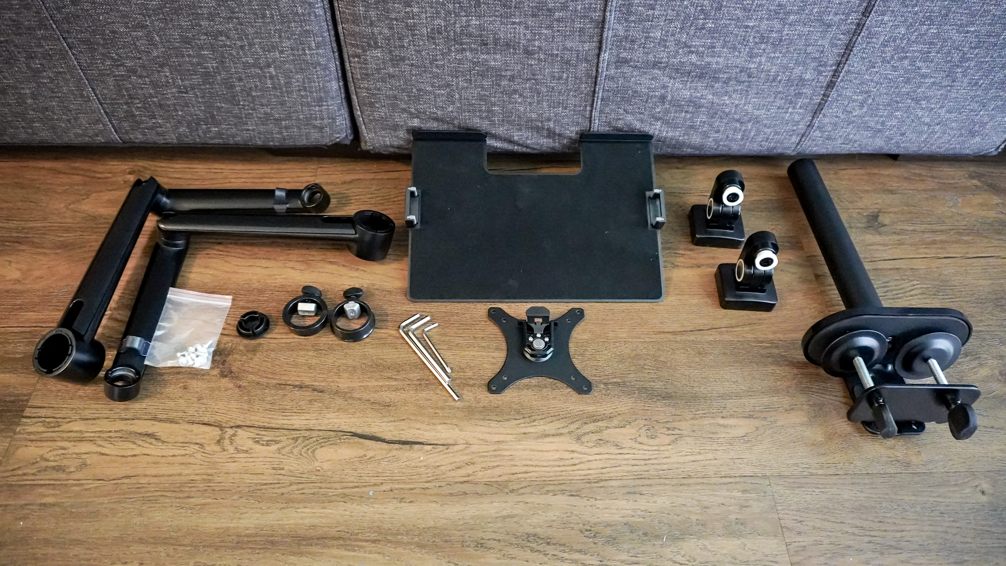 All of the pieces of the Viozon monitor arm and laptop mount laid out on the floor