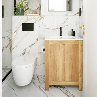 Bathroom with marble surfaces and wooden storage cabinet