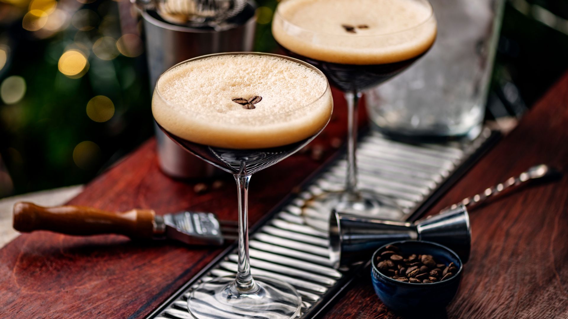 An image of two espresso martinis on a wooden bar