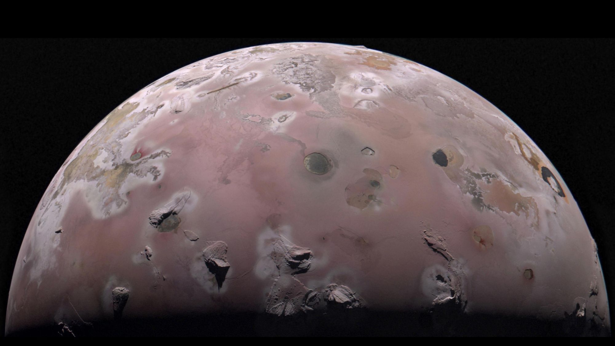  A pinkish-brown moon is seen (it's upper hemisphere). There are dark splotches on it.