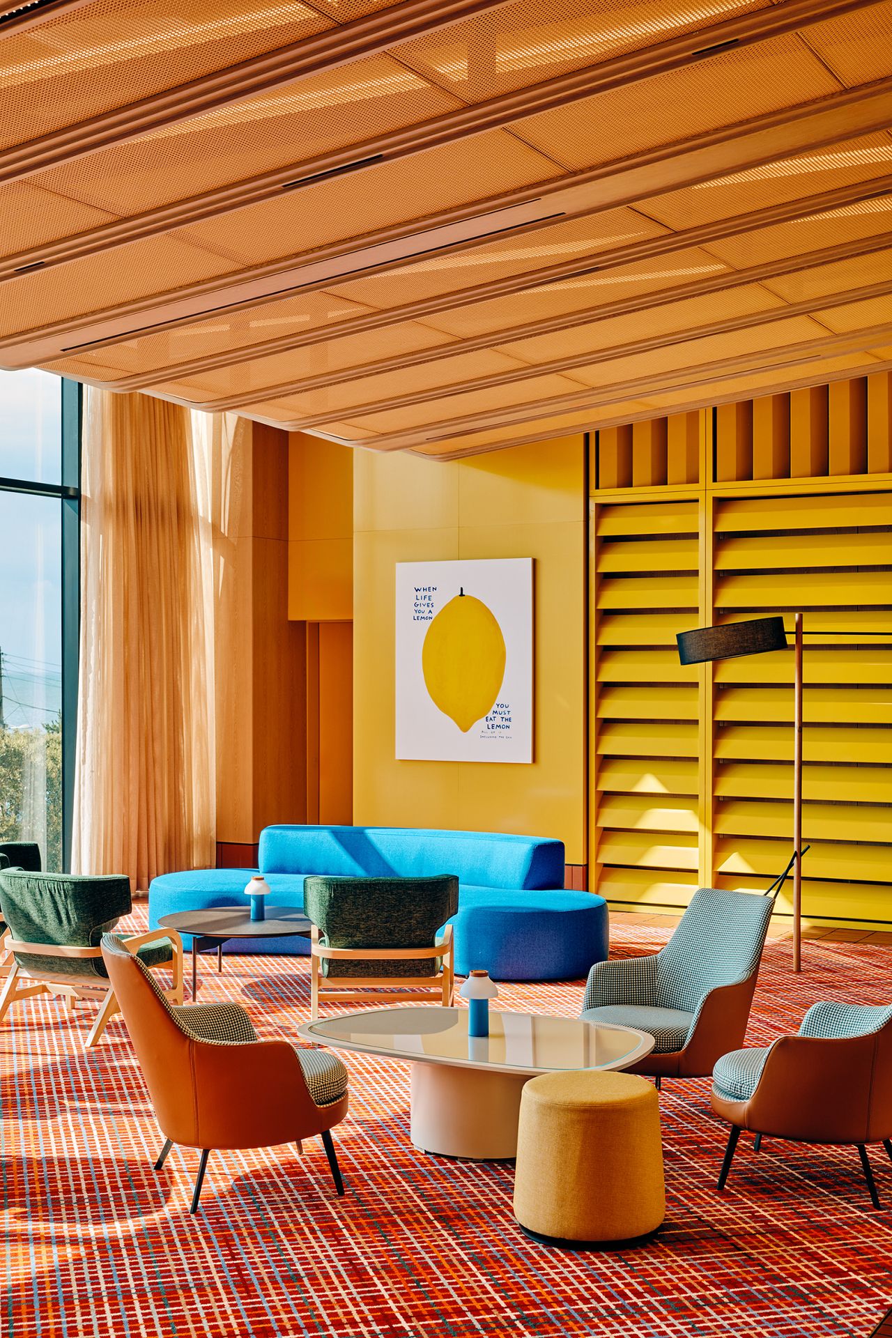 A retro-futuristic hotel lobby drenched in color.