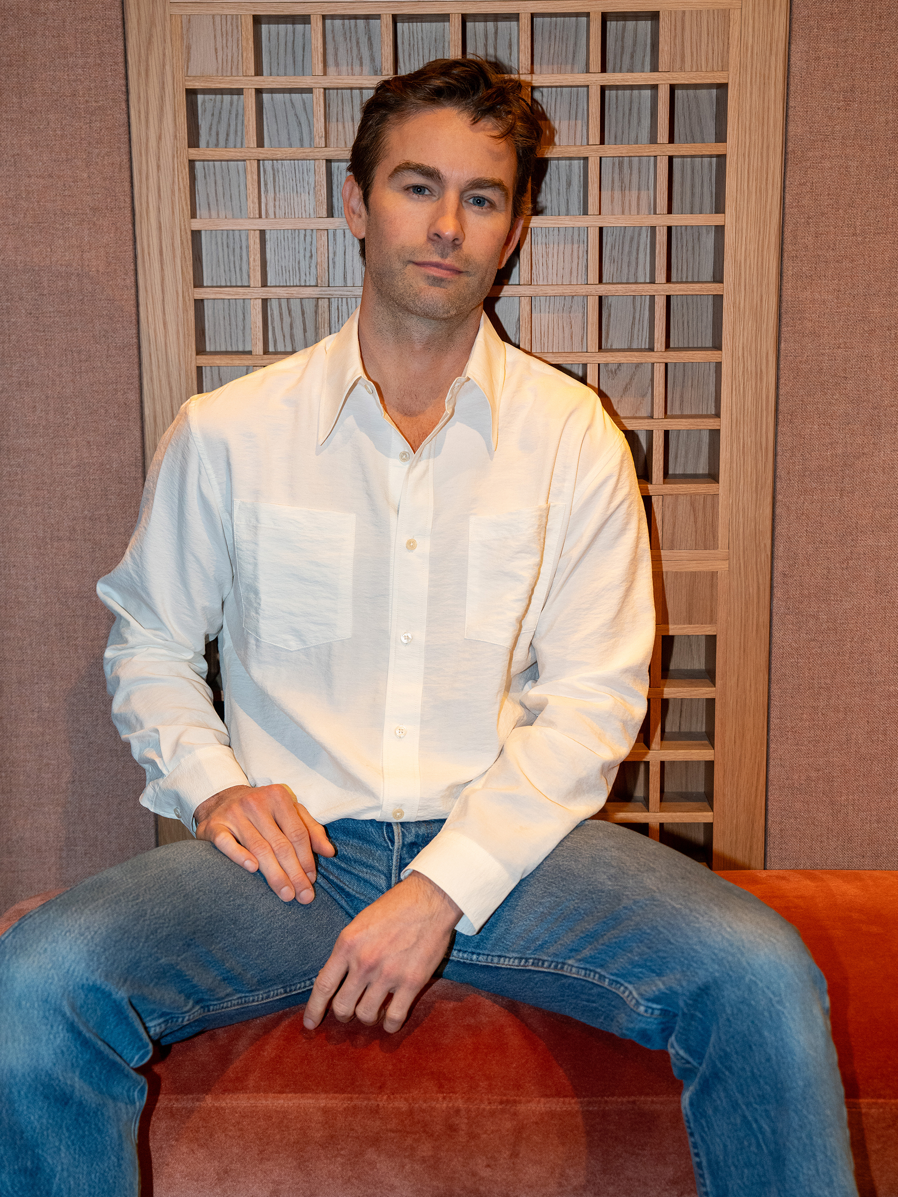 Chace Crawford wearing a plain white button-down shirt and blue jeans.