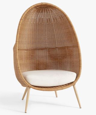 A woven cane egg chair with soft natural cotton twill cushions filled with foam