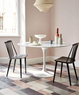 Pink, grey, white tiling in a dining area in a kitchen with white dining table with black chairs - Amtico