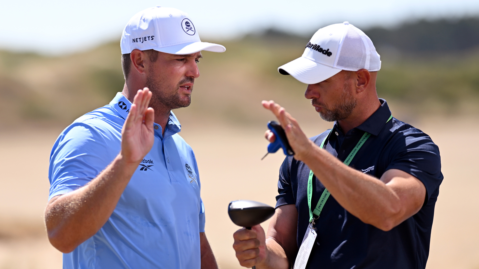 Bryson DeChambeau interacts with a member of his team on the driving range prior to The 154th Open Championship
