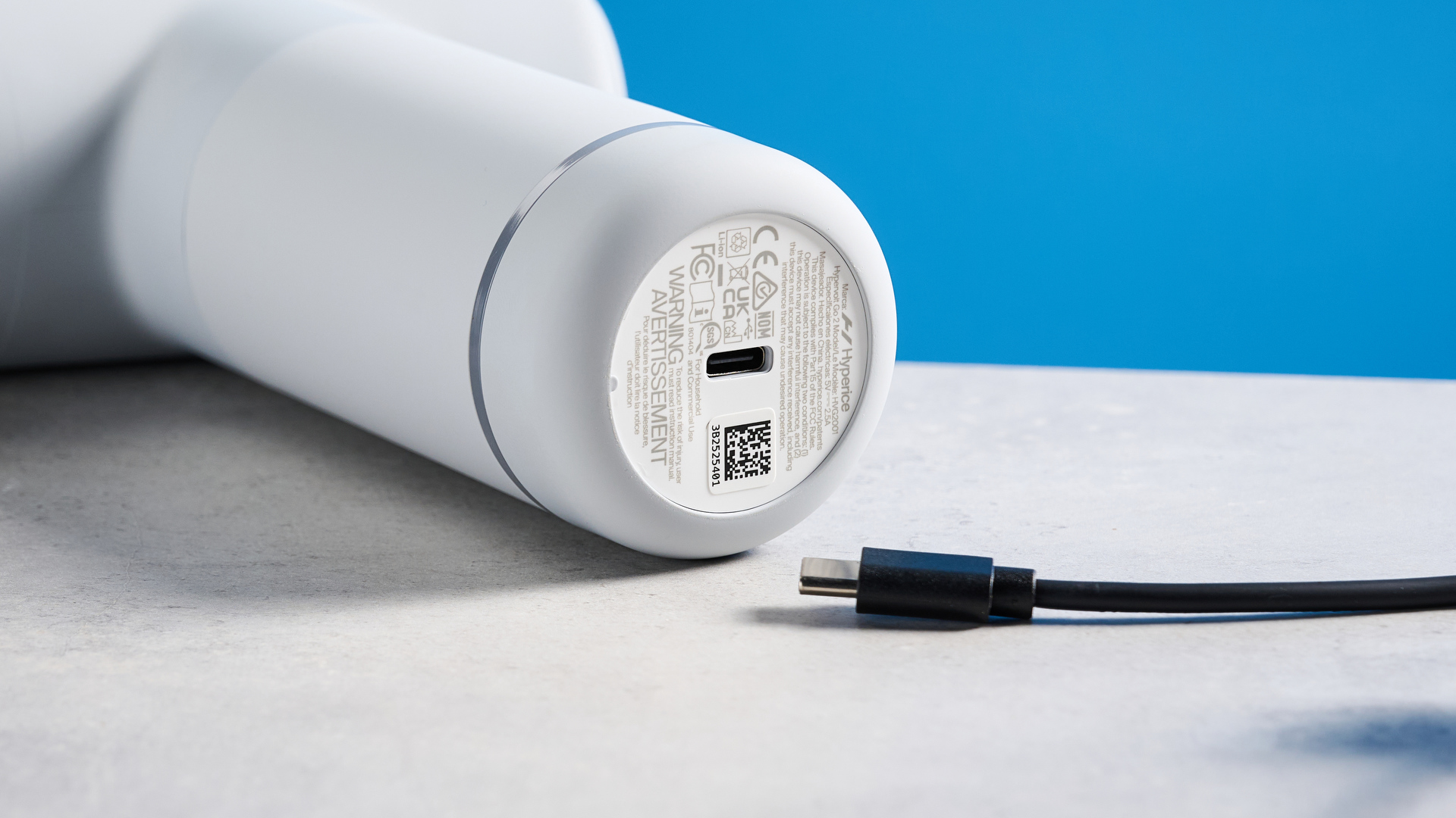 the hyperice hypervolt go 2 massage gun in white/gray with a bullet head attachment, flat head attachment, and a usb-c charging port