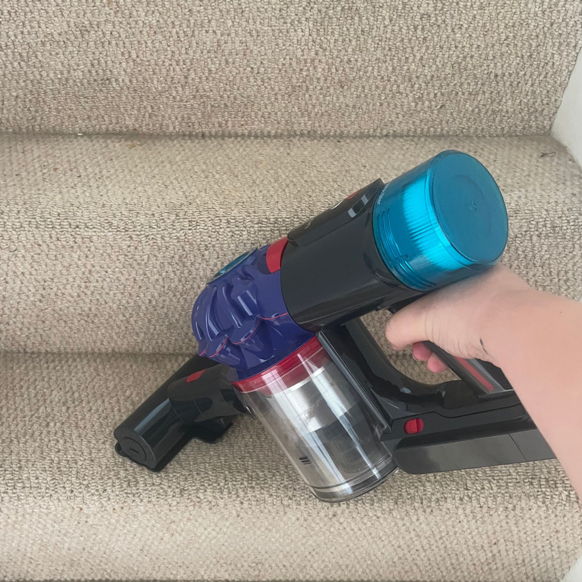 Using the handheld section of the Dyson V10 Konical vacuum to vacuum carpeted stairs