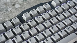 A gray GravaStar Mercury K1 Pro mechanical keyboard, with spider legs