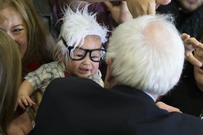 Democratic presidential candidate Sen. Bernie Sanders, I-Vt., right, meets 3-month-old Oliver Lomas, of Venice, Calif., who was dressed as Sanders during a rally at Bonanza High School.
