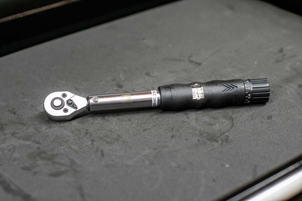 M Part torque wrench on a black workbench