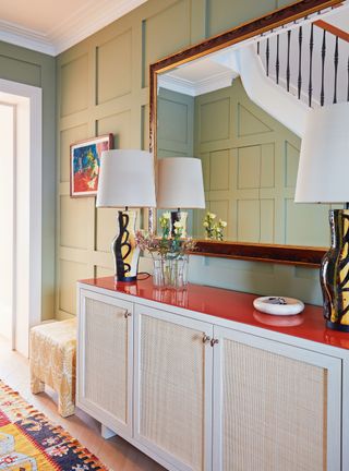 Traditional entryway with pale green painted panels and sideboard