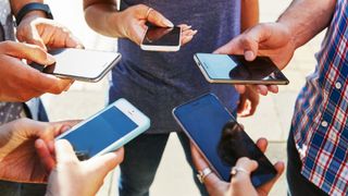 Best smartphones 2022: image shows group of people looking at smartphones