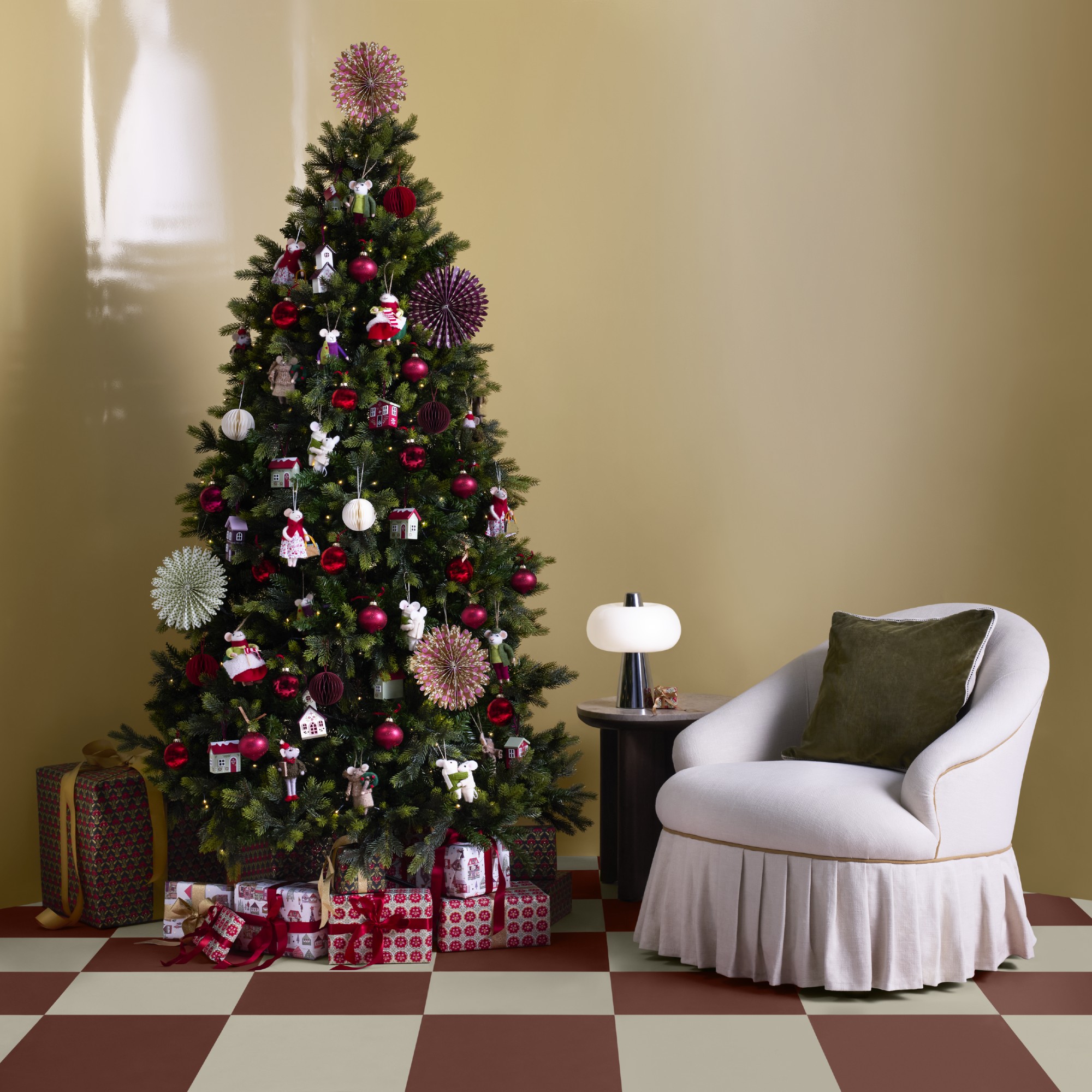 A butter yellow room with a chequered floor and a Christmas tree decorated with John Lewis decorations from the Cherisher range.