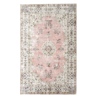 A washable pink and neutral area rug