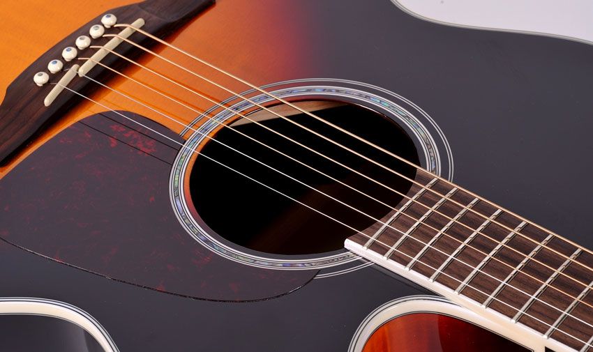 Under the gloss three-tone 'burst finish lies an X-braced solid spruce top; the back and sides are laminated flame maple