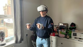 PSVR2- Man using virtual reality headset and controllers.