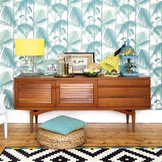 yellow and green hallway with tropical print and retro sideboard