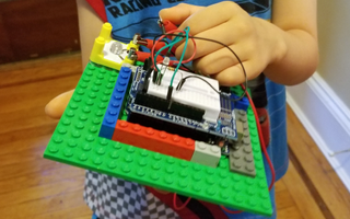 My son, plugging wires into an Arduino-Lego project