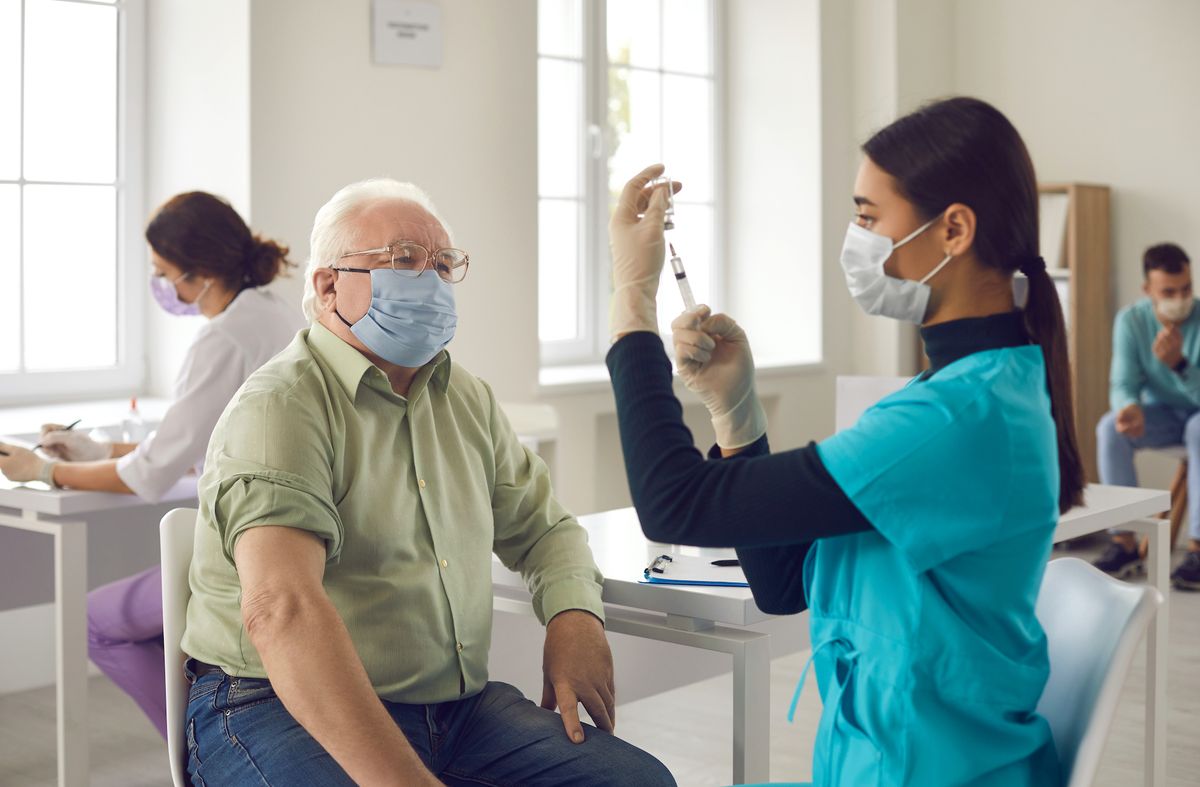 An older man being vaccinated.