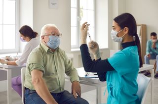 An older man being vaccinated.