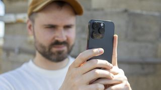 A close-up of a man holding an iPhone 14 Pro