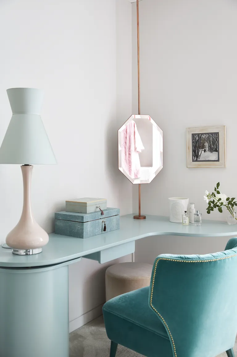 guest bedroom with aqua blue custom desk/dressing table with turquoise upholstered velvet chair, mirror, ornaments, retro table lamp