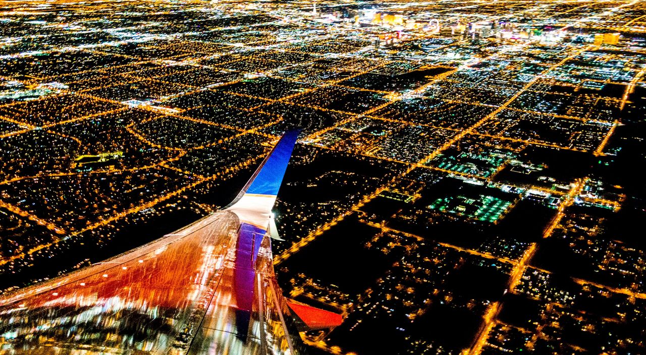 plane flying over city lights