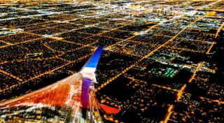 plane flying over city lights