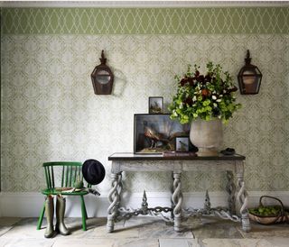 green wallpaper with a border in a hallway