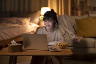 Young Chinese woman watching movie on laptop