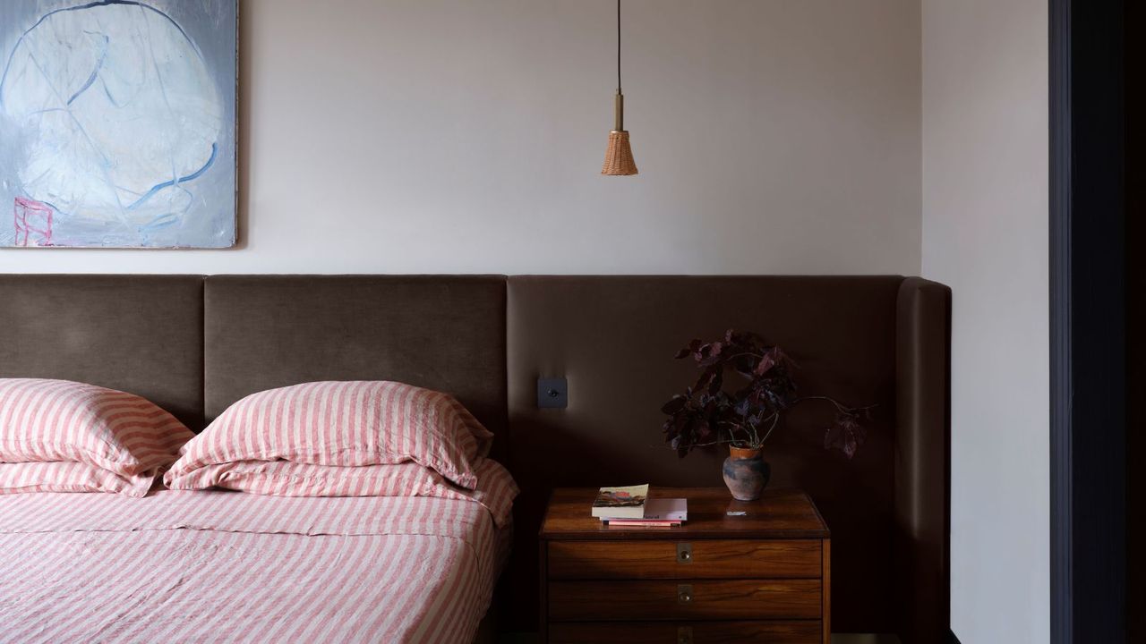 neutral bedroom with striped bedding and wooden nightstand