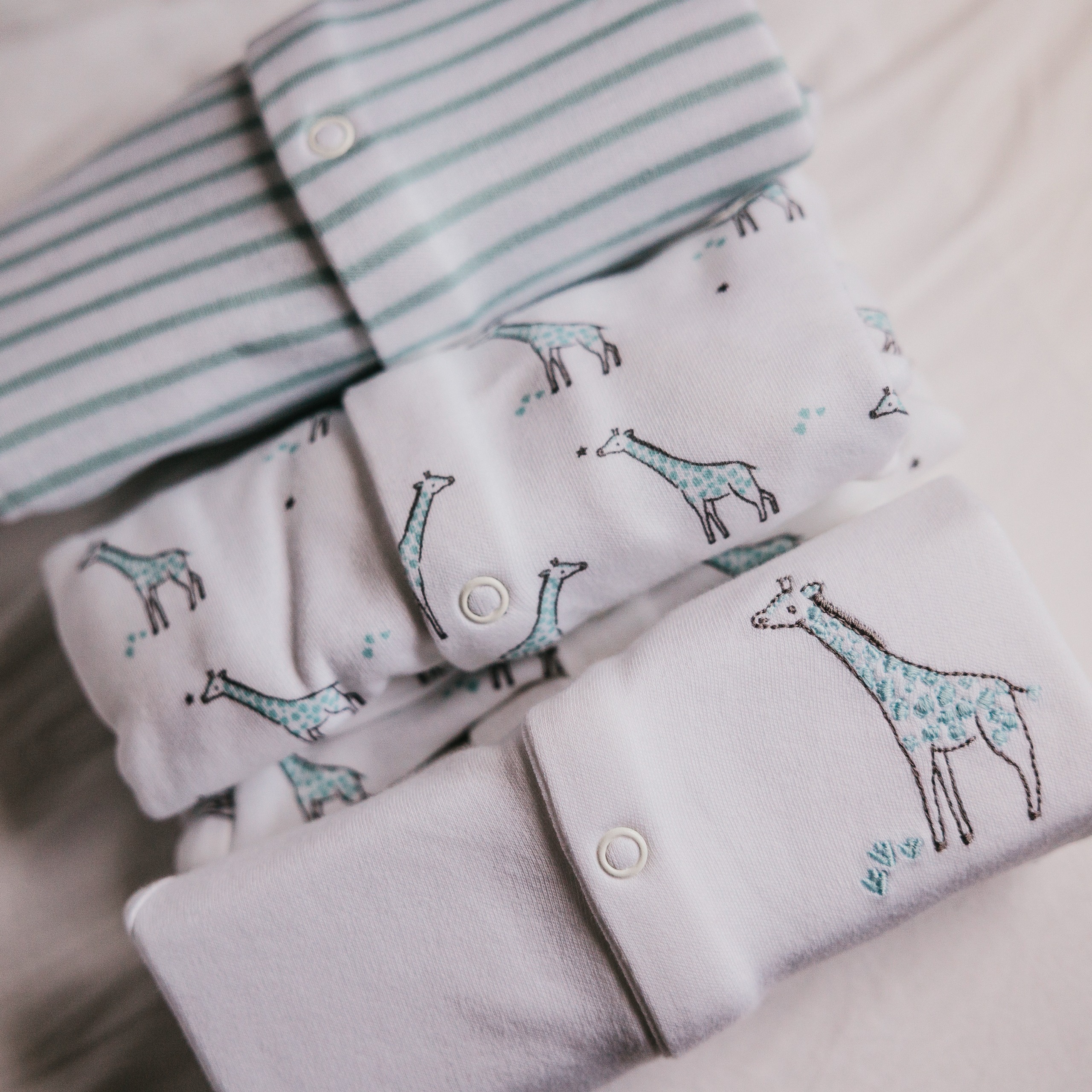 A close-up of three giraffe sleepsuits from John lewis