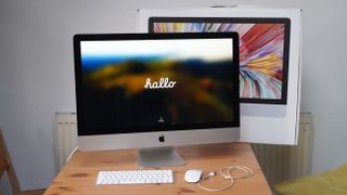 iMac 2020 27-inch next to box on table with 'hallo' screen