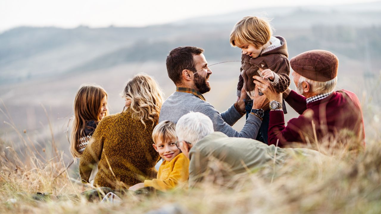 A multigenerational family on a picnic in the fall.