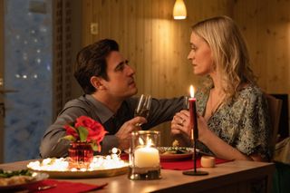 claes bang as jp the prick and Anne-Marie Duff as grace sitting at a dinner table in a cabin in bad sisters season 1