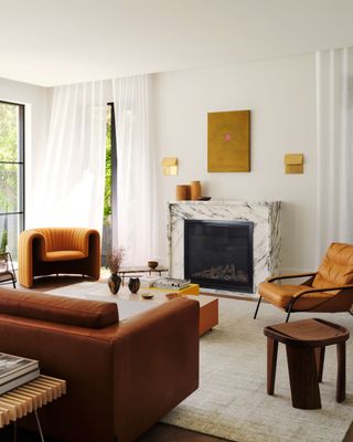 a white living room with a leather sofa and velvet accent chair