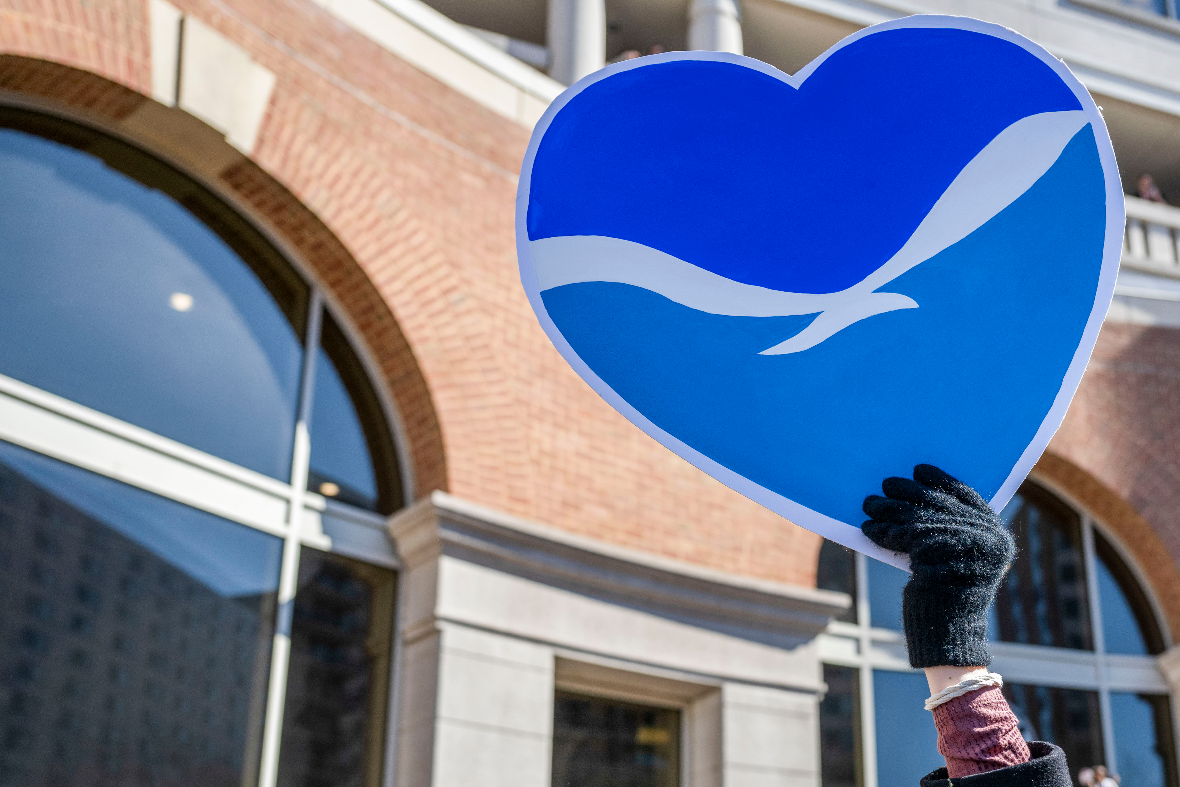 the noaa logo in the shape of a heart is held up by someone.