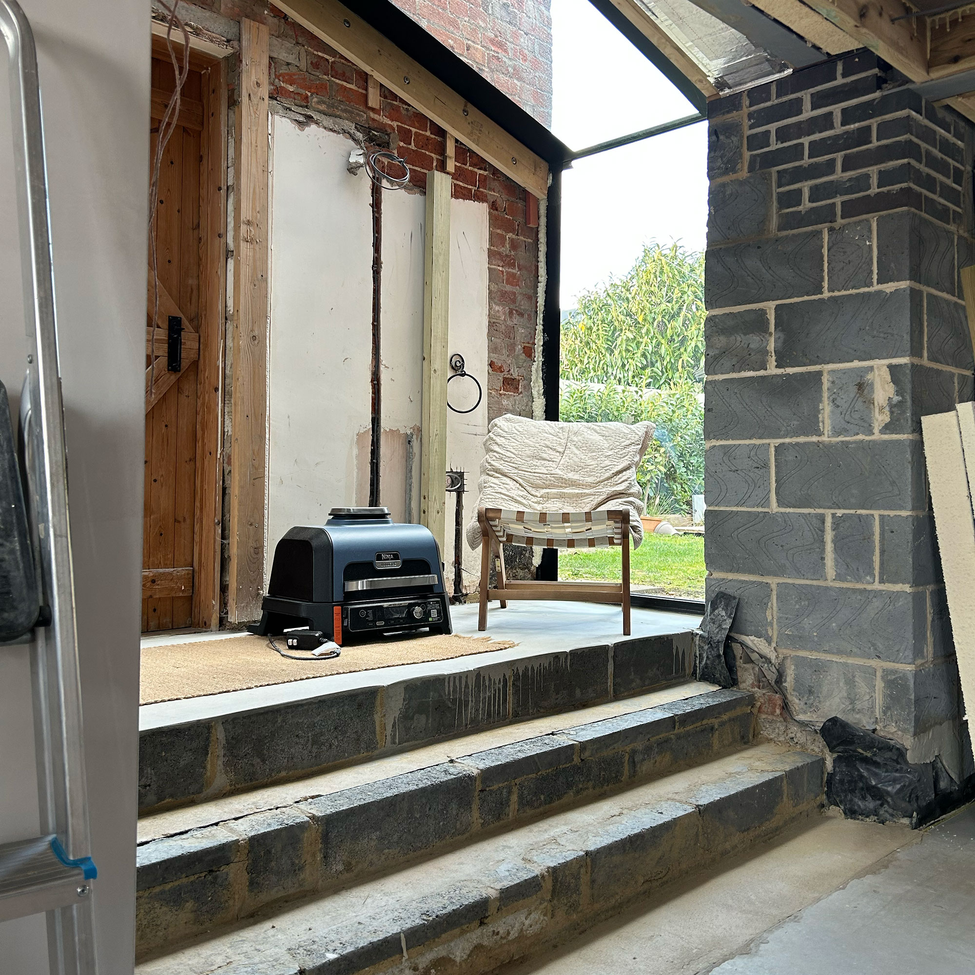 Extension being built with unclad walls and concrete steps