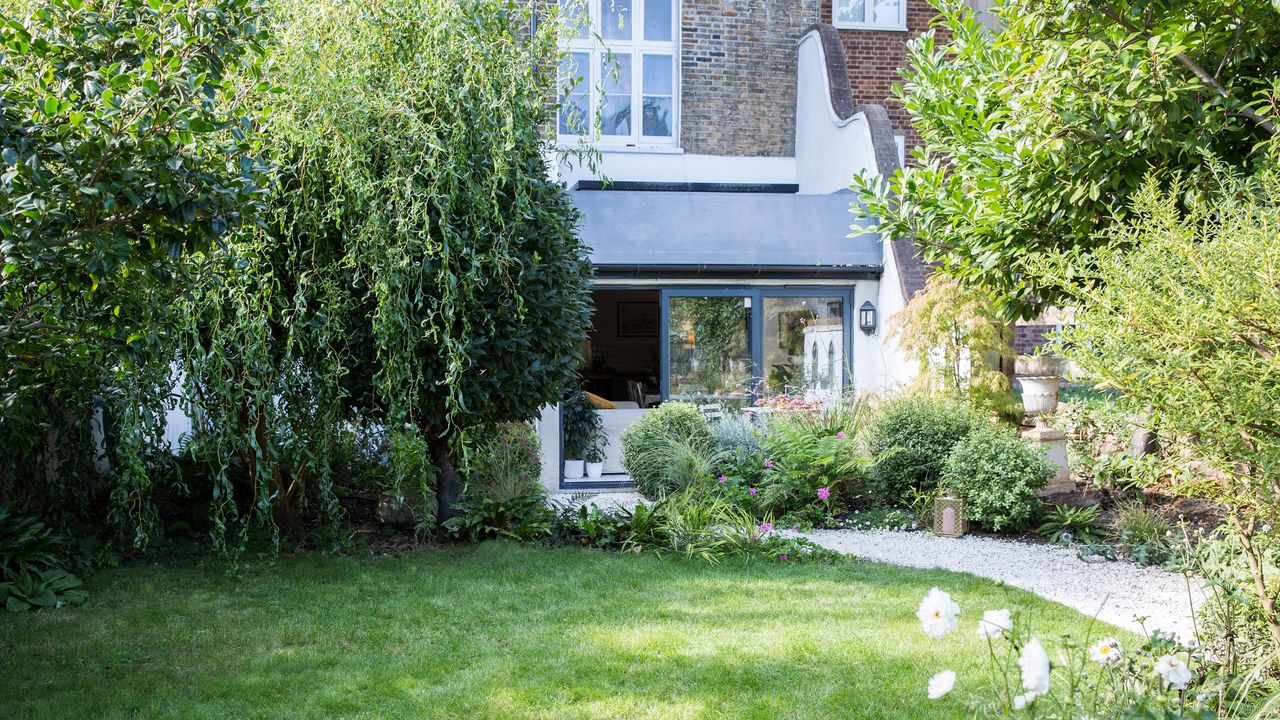 Lawn with conservatory and white wall