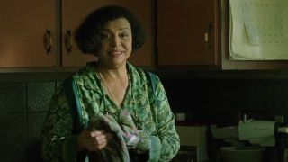 Gloria Foster smiles while taking off oven mitts in her kitchen in The Matrix.