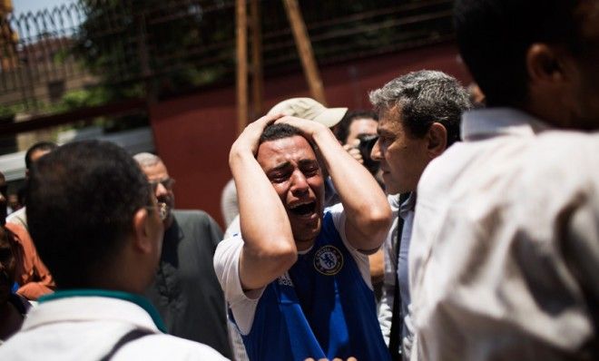 An Egyptian man cries after carrying the corpse of his brother 