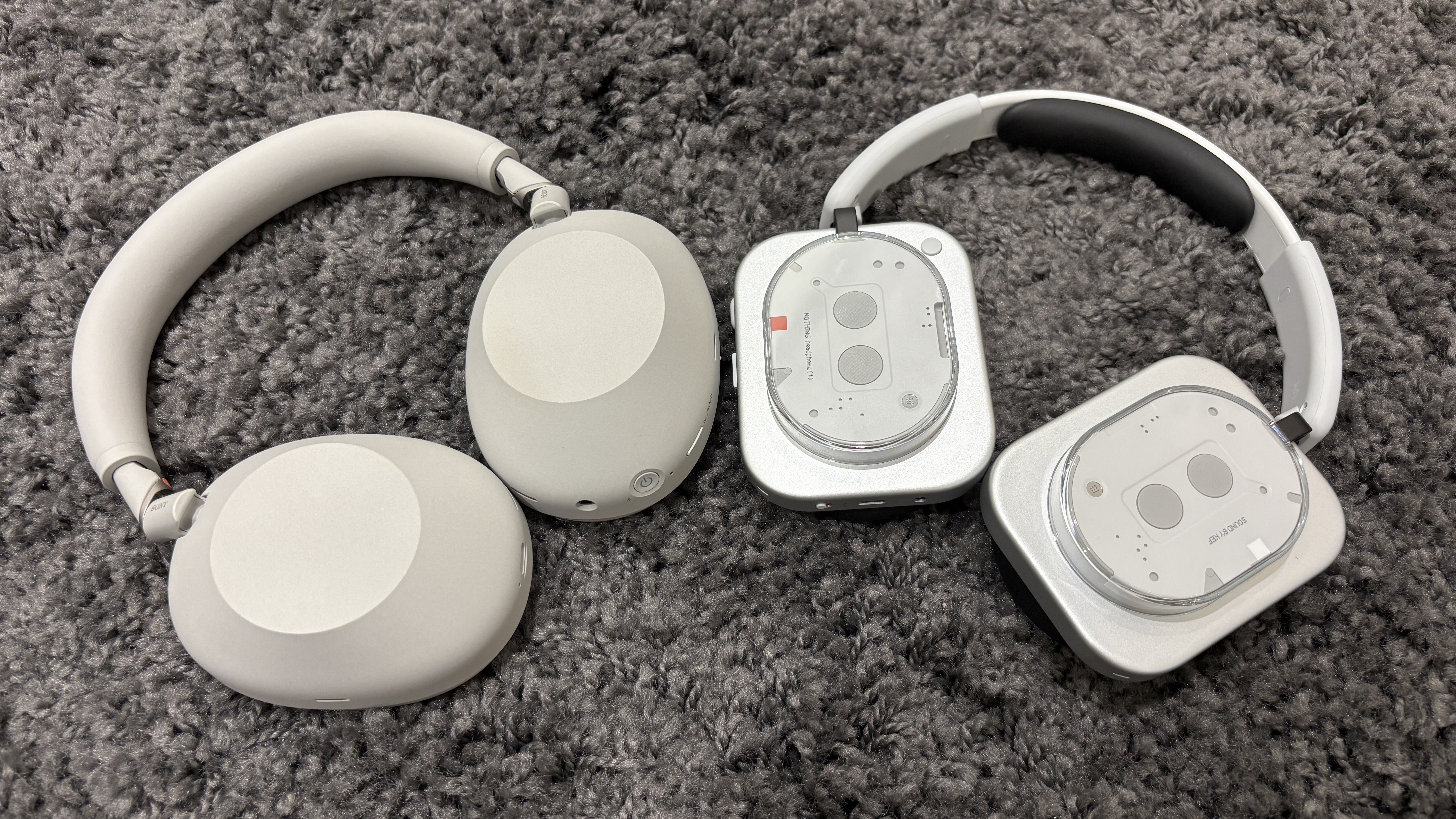 Sony WH-1000XM6 and Nothing Headphone 1 on a grey fluffy carpet