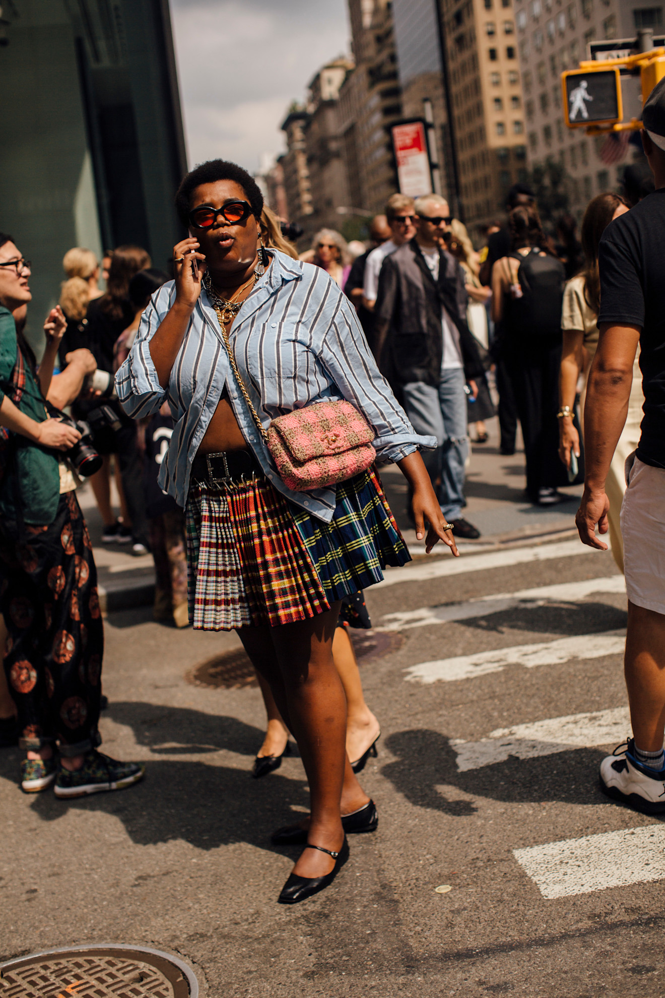Gabriella Karefa Johnson wearing a plaid skirt, blue striped shirt, and black Mary Jane shoes