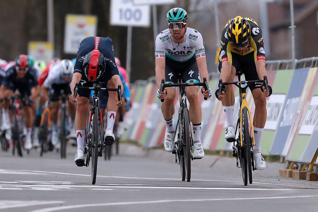 Tom Pidcock and Wout van Aert lunge for the line at the finish of Amstel Gold Race 2021