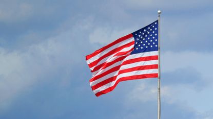 The US flag set against a blue sky.