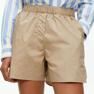 model wearing beige arket poplin shorts