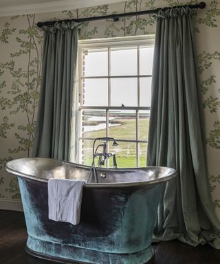 Bathroom curtain ideas with long green curtains, matching a green metal bathtub